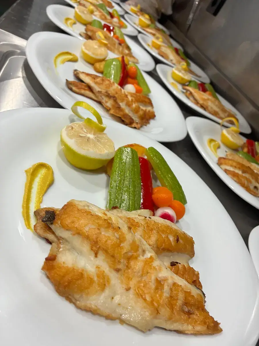 Pescado fresco con limón y verduras en un yate