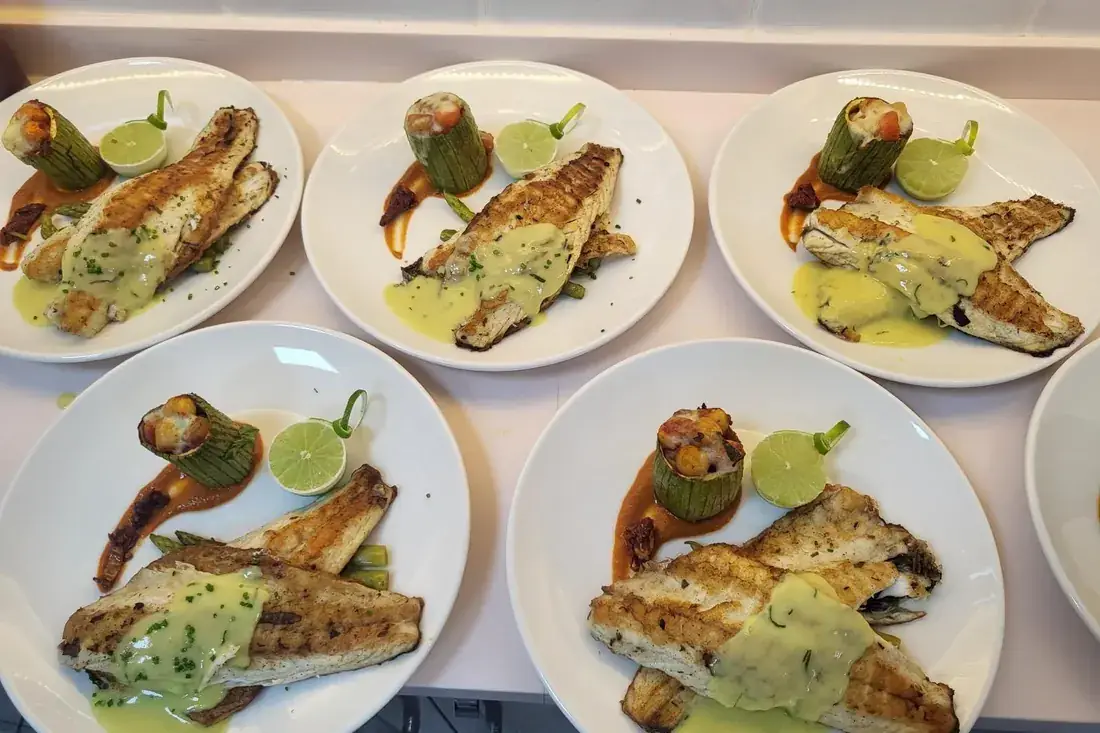 Platos de lubina a la parrilla preparados a bordo