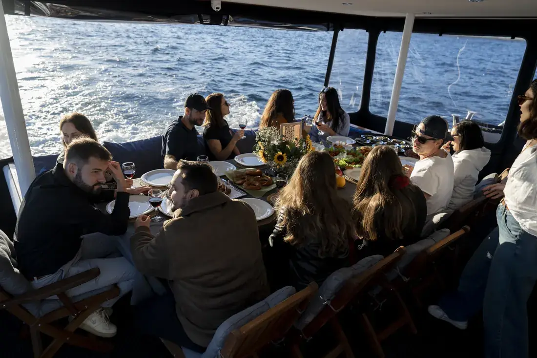 Almuerzo en grupo en la cubierta cubierta de un yate camino de Anadolu Kavağı