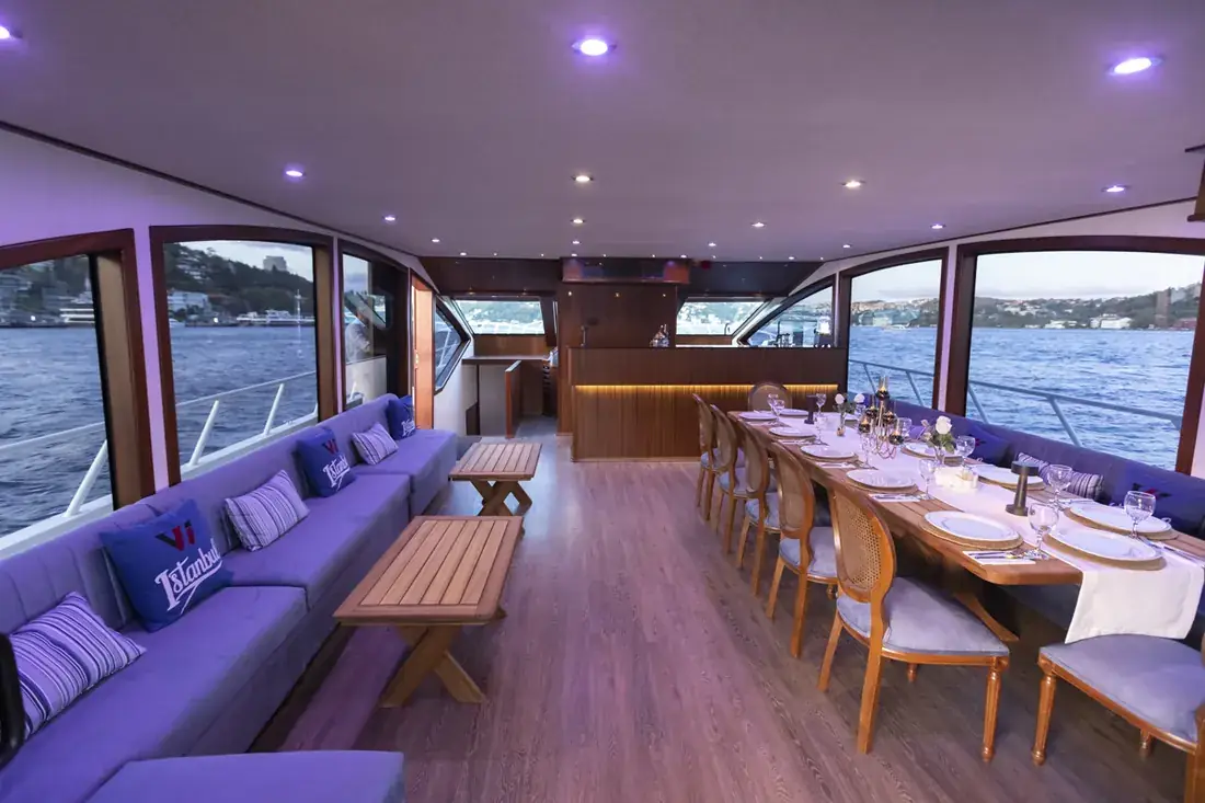 Salón del yate con una mesa larga para el almuerzo