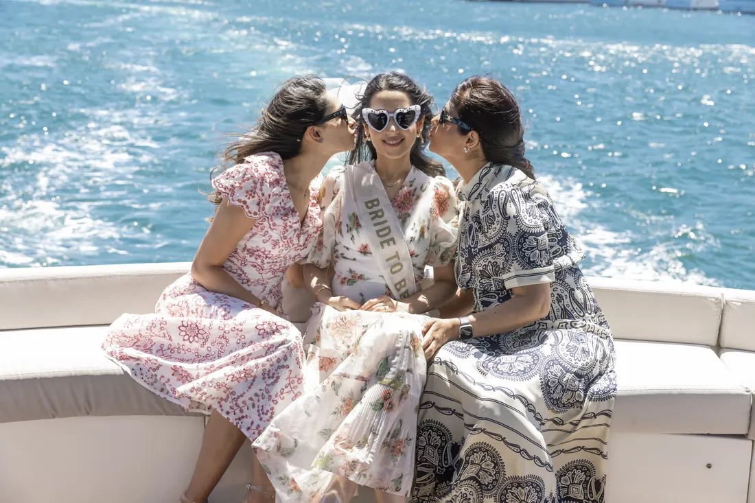 Friends kissing the bride to be on a yacht