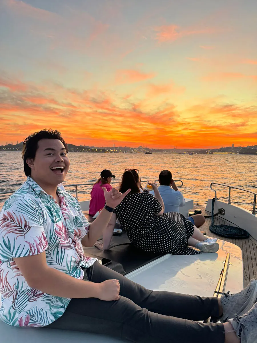 Guest on deck under an orange sunset sky on the Bosphorus