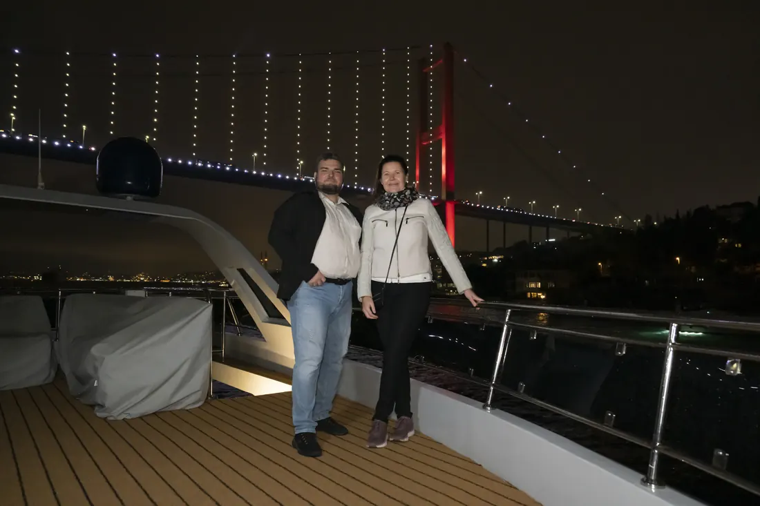 Guests posing with the Bosphorus Bridge at night