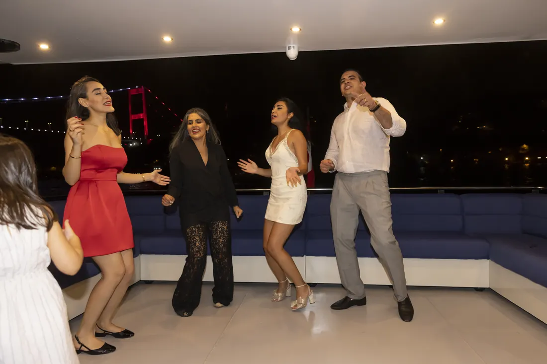 Family dancing on a yacht deck at night