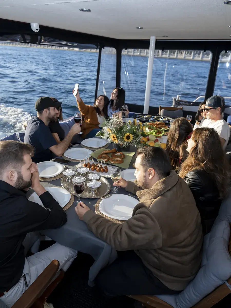 Almuerzo de grupo en la cubierta con toldo de un yate en el Bósforo