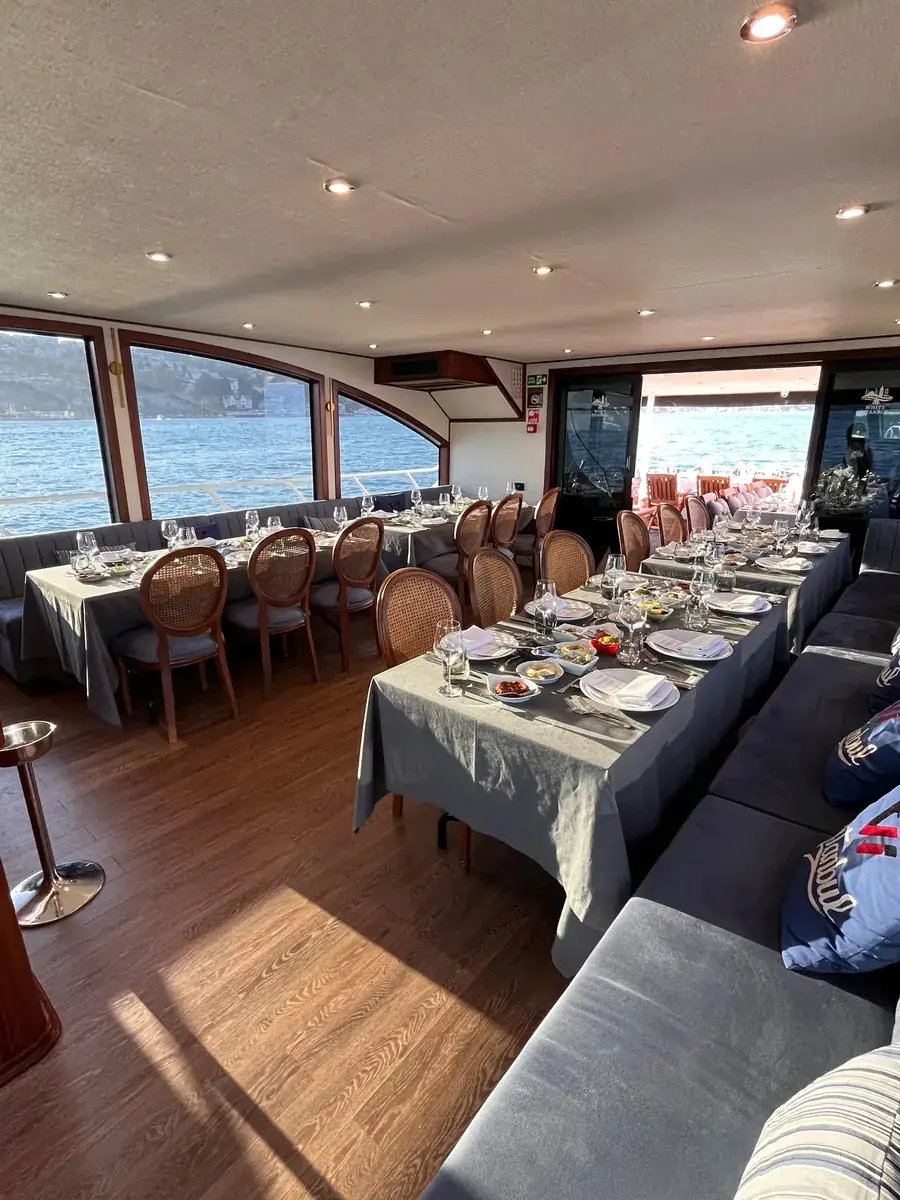 Salón de yate con mesas preparadas para el almuerzo