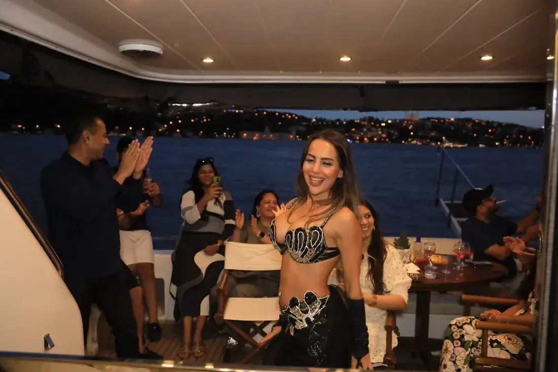 Belly dancer with guests on a yacht at night