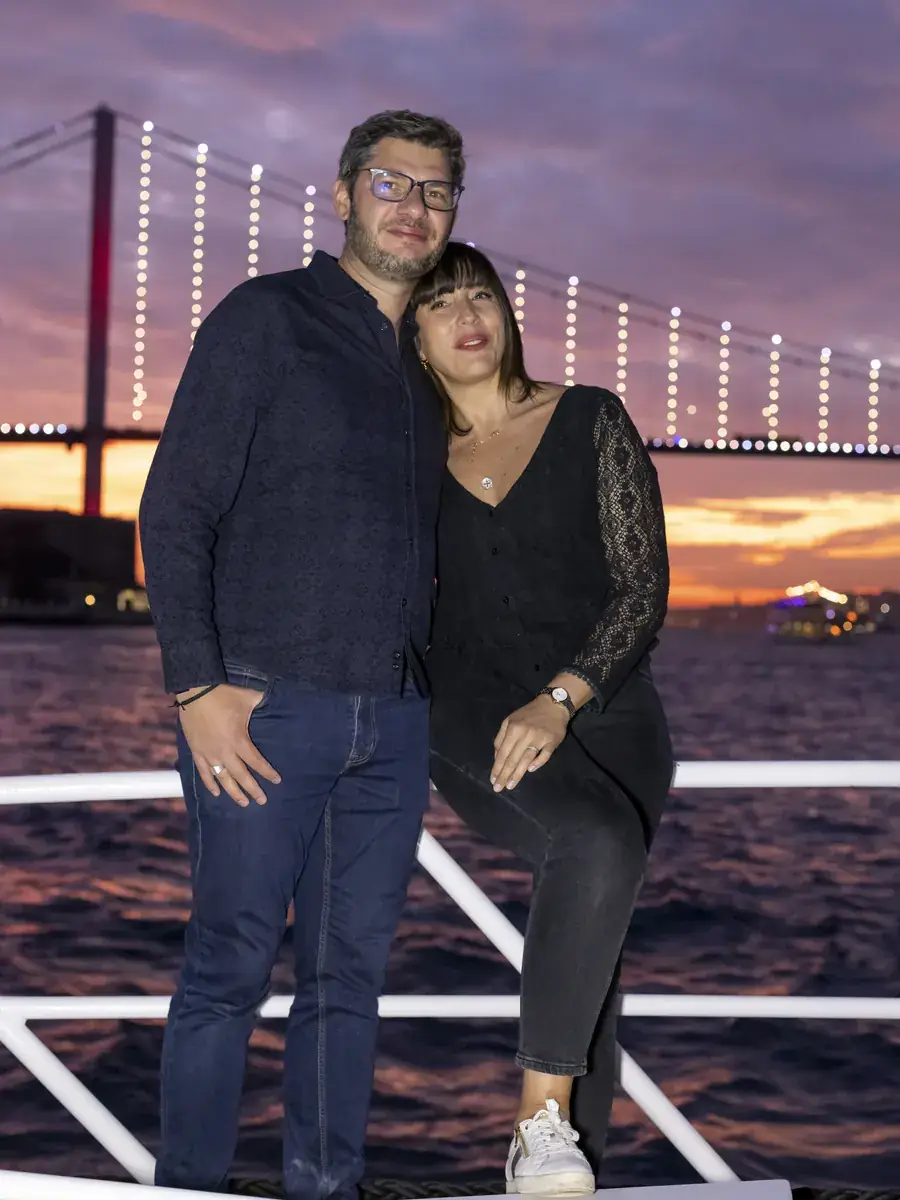 Couple on a private yacht with the illuminated Bosphorus Bridge