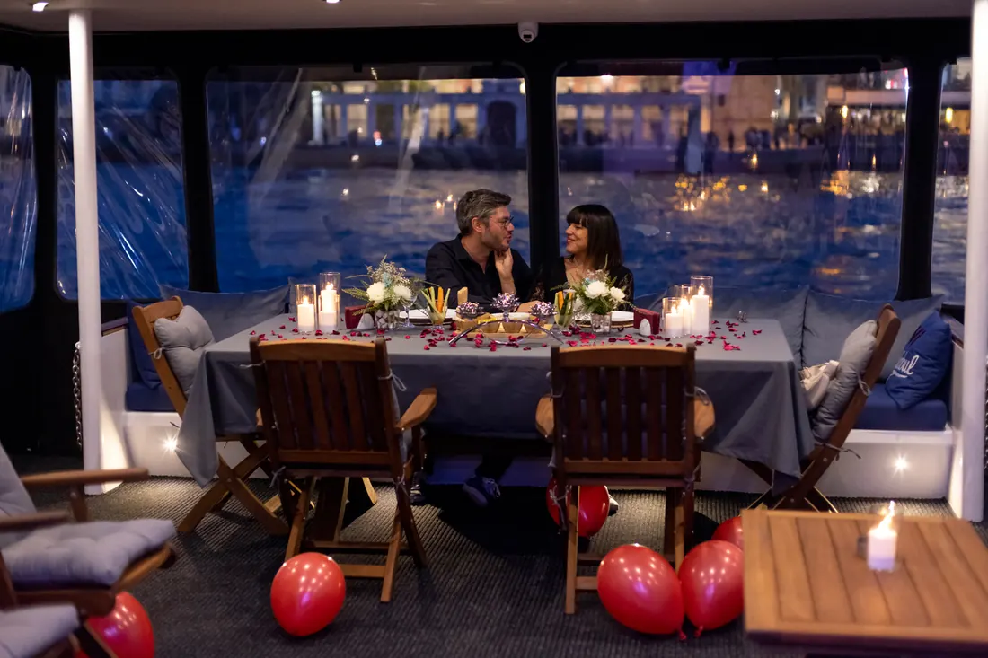 Couple at a candlelit dinner on a yacht