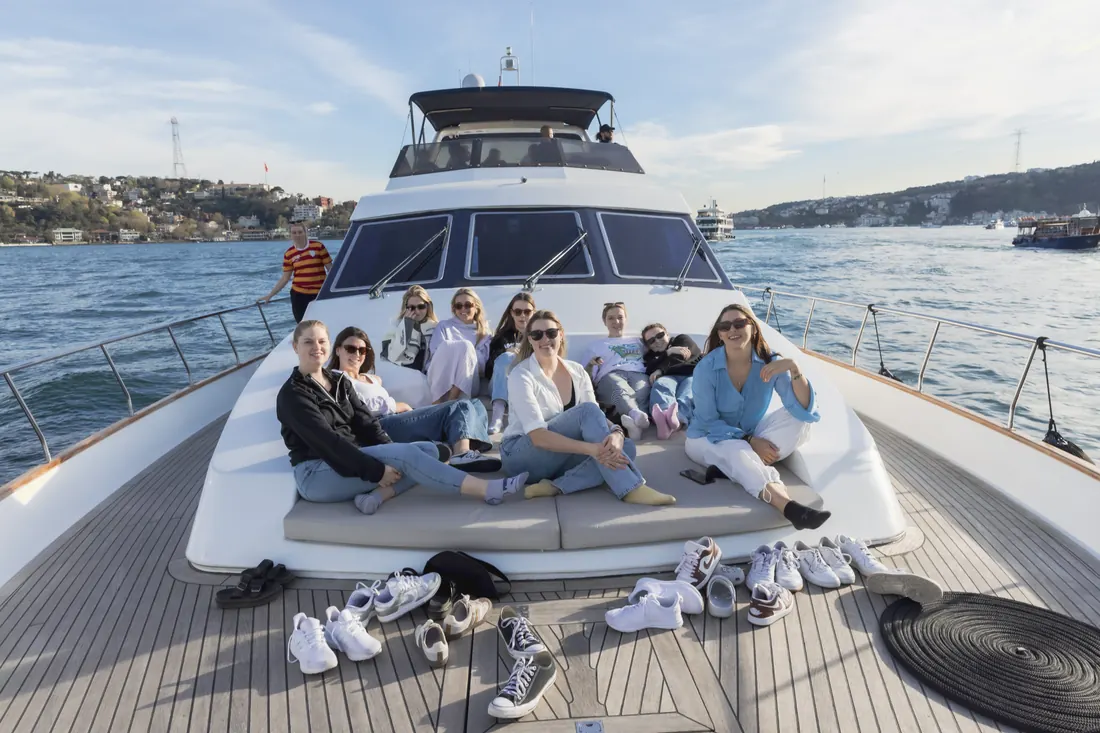 Friends celebrating on the bow of a yacht