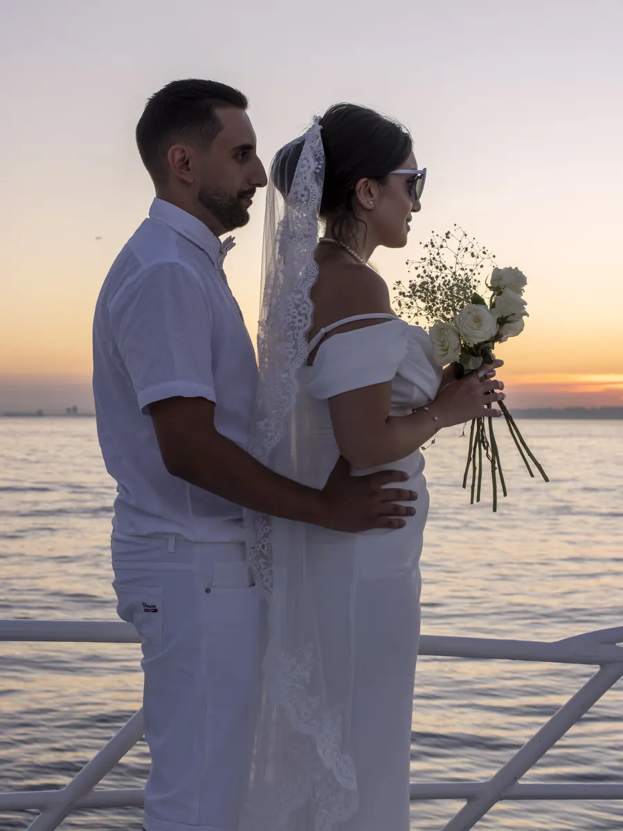 Novios abrazados en un yate al atardecer