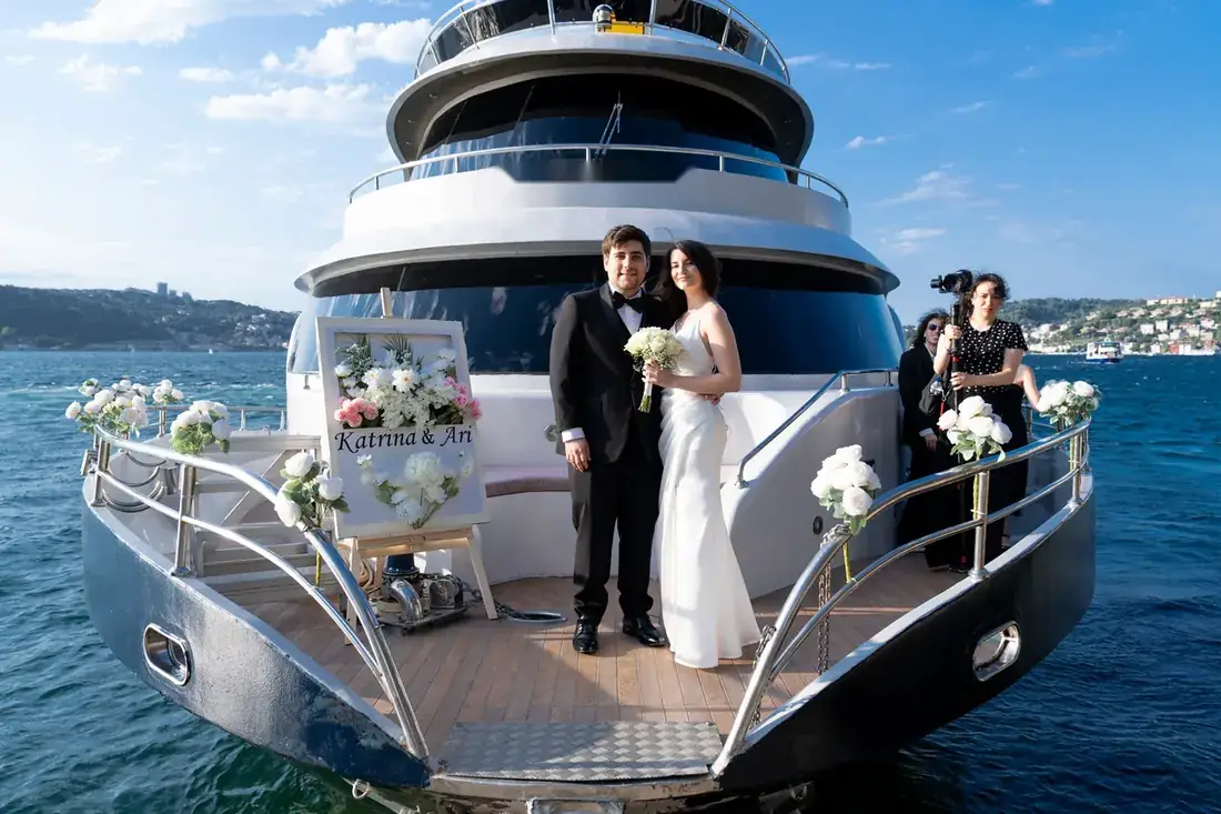 Novios en la proa de un yate decorada con flores
