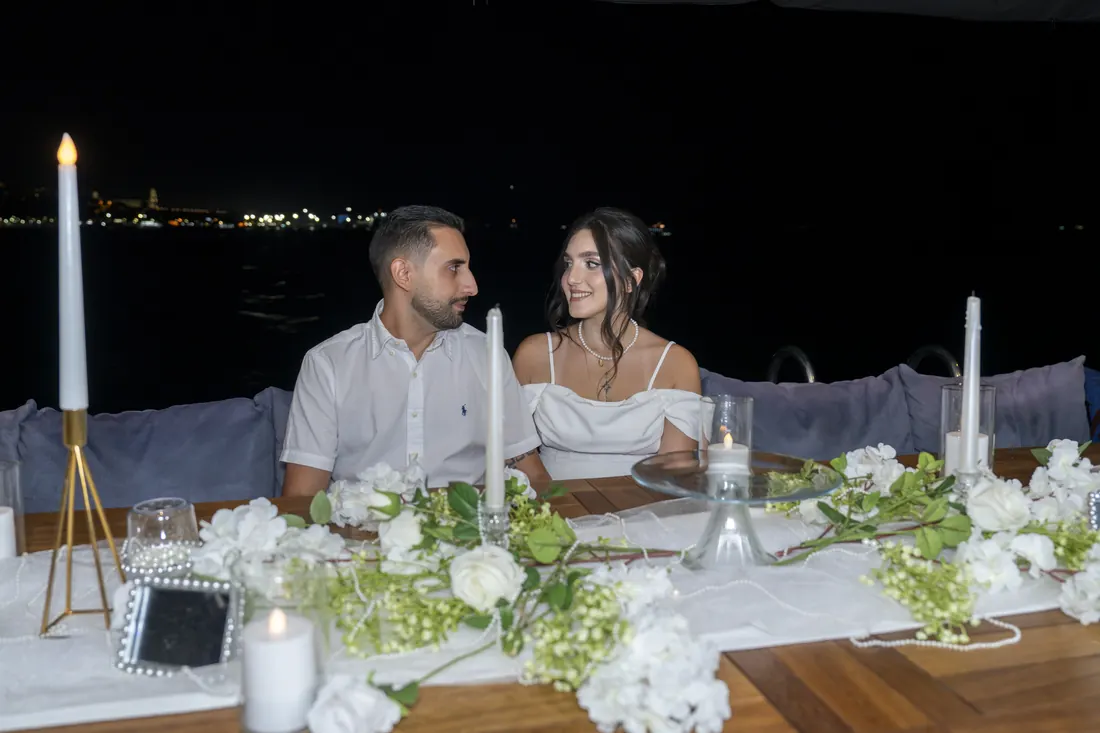 Recién casados en una mesa iluminada con velas en un yate