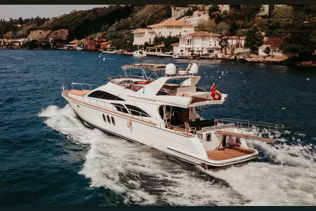 Riviera motor yacht cruising past Bosphorus mansions