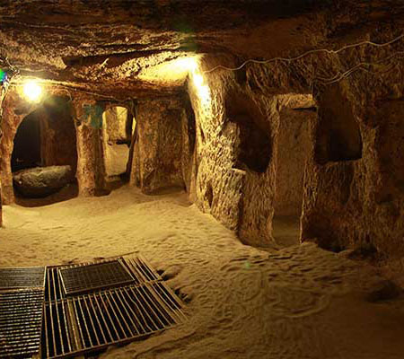 Rolling stone door and narrow passage in Özkonak Underground City, Cappadocia