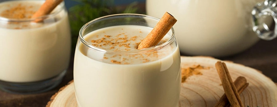 Glass of thick boza topped with cinnamon and roasted chickpeas