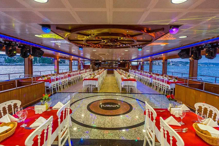 Comedor interior con mesas preparadas para un crucero con cena en Estambul