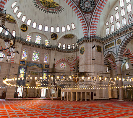 Interior of the Blue Mosque with blue Iznik tiles, domes and chandeliers